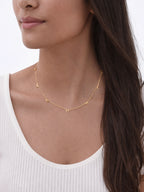 18k gold plated bow charm necklace on model with long hair, dainty minimalist jewelry, waterproof everyday necklace styling