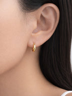 Hailey gold huggie hoop earrings worn by a model | myEdzy
