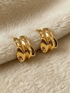 Bold gold sculptural earrings chunky statement jewelry modern fashion styling | myEdzy