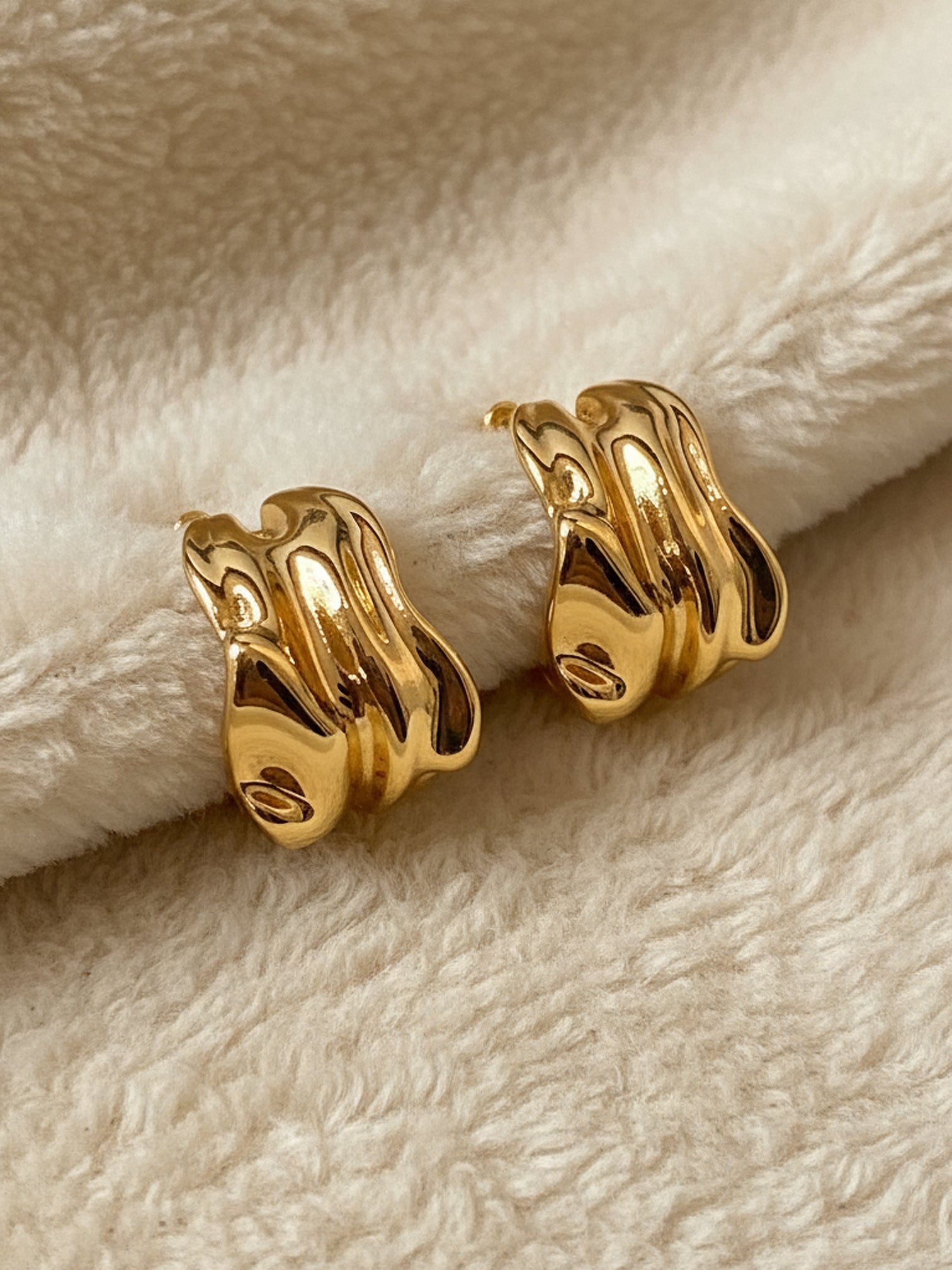Bold gold sculptural earrings chunky statement jewelry modern fashion styling | myEdzy