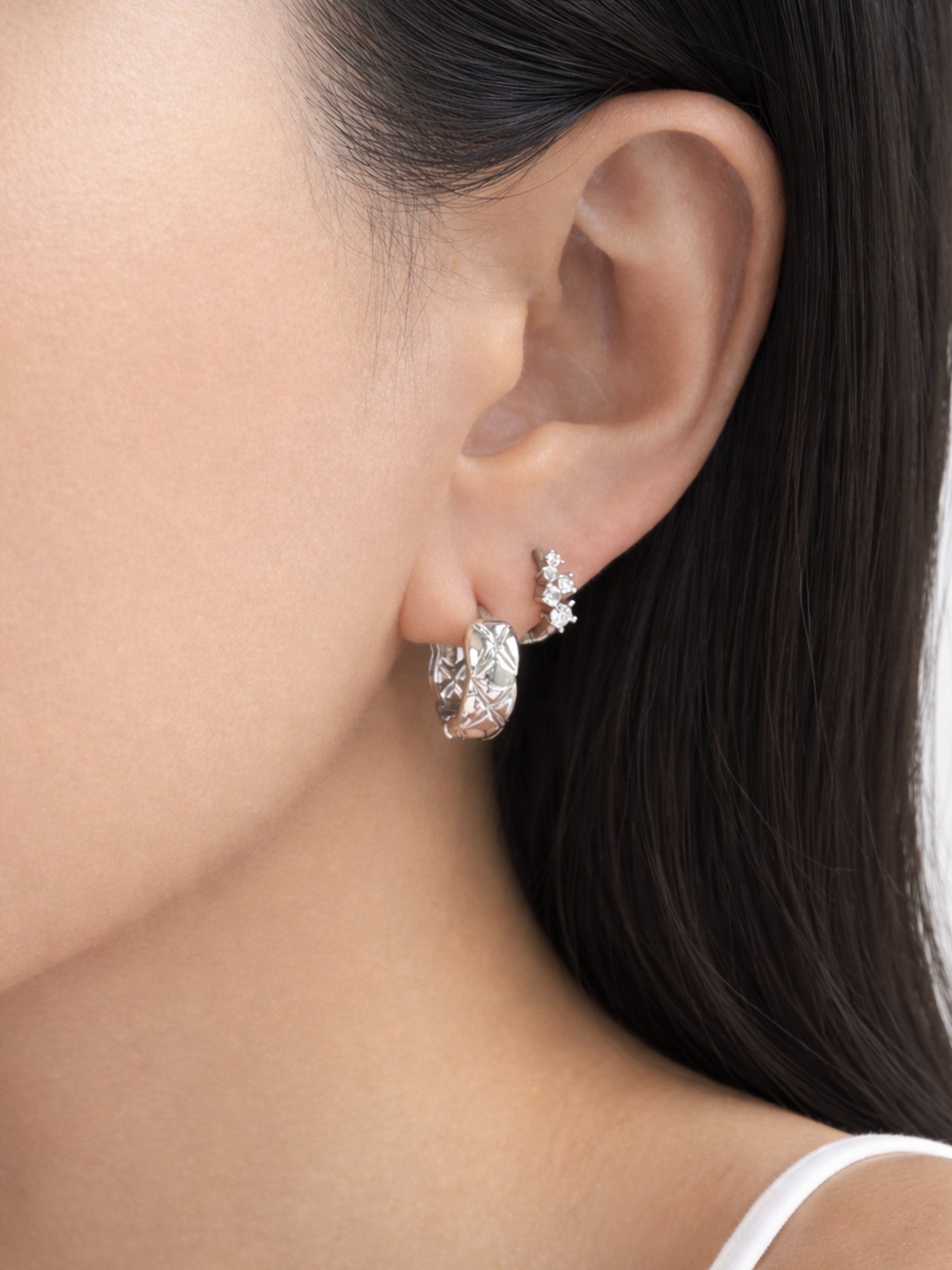 Close-up of a model wearing myEdzy Coco Quilted Huggie Hoops in White Gold