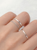 Slim white gold silver stacking ring worn on finger simple dainty band