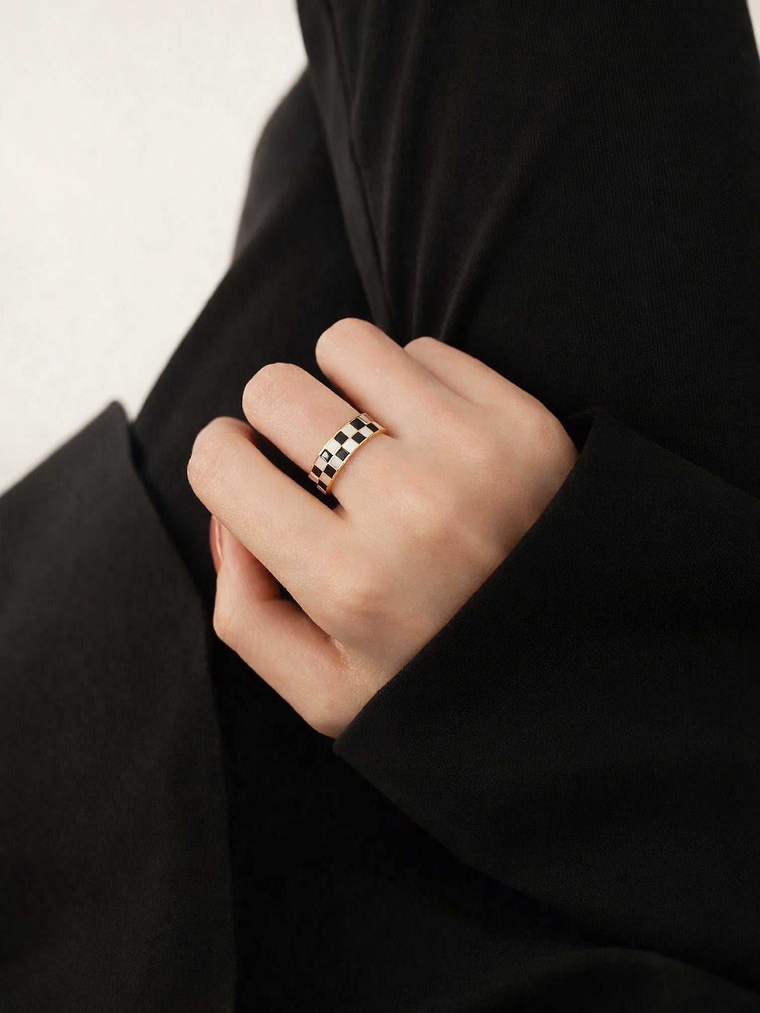 Irelina 18K gold plated black and white checkered statement ring worn on hand with black outfit, modern chic styling by myEdzy