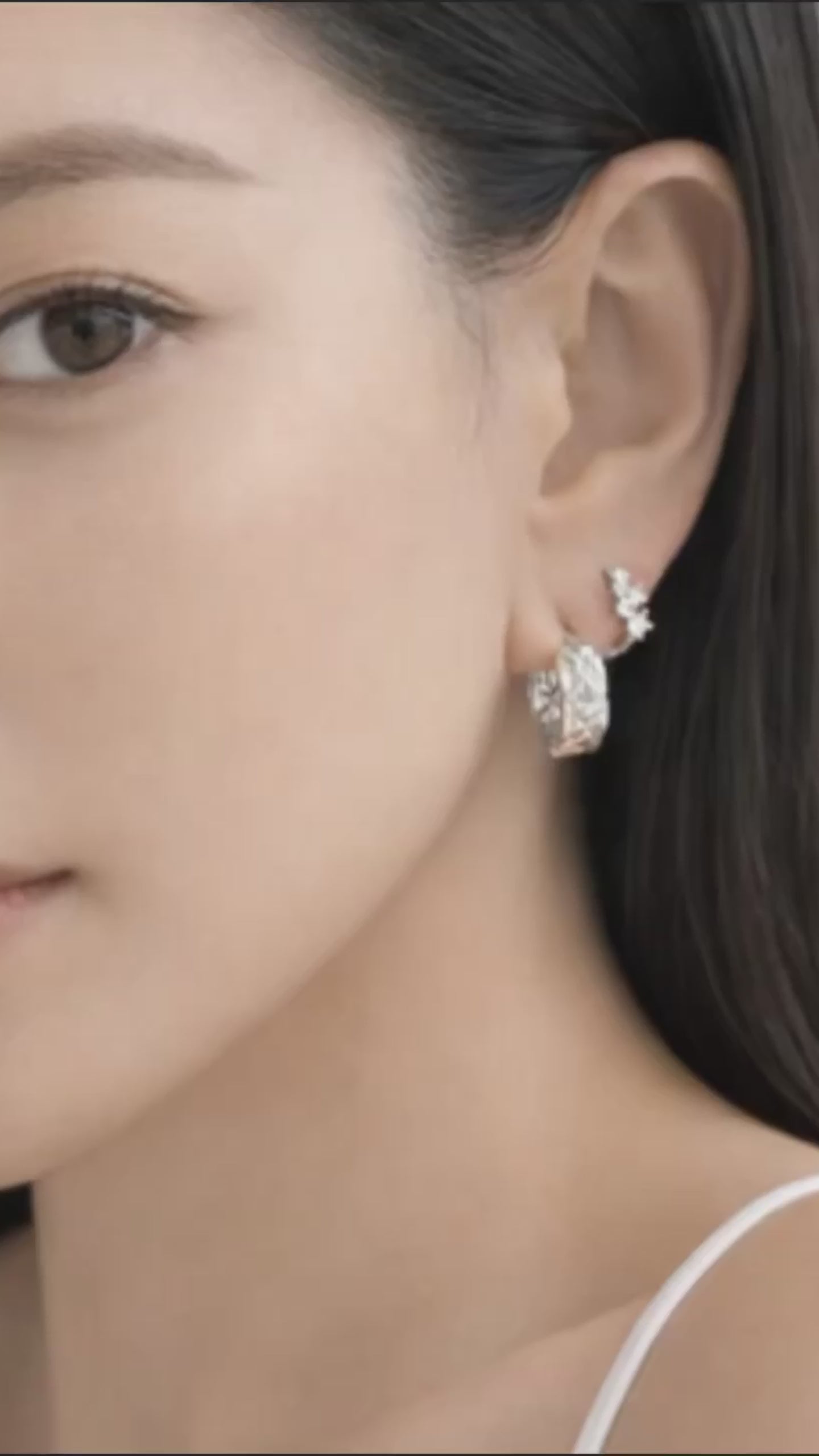 Close-up of a model wearing myEdzy Coco Quilted Huggie Hoops in White Gold