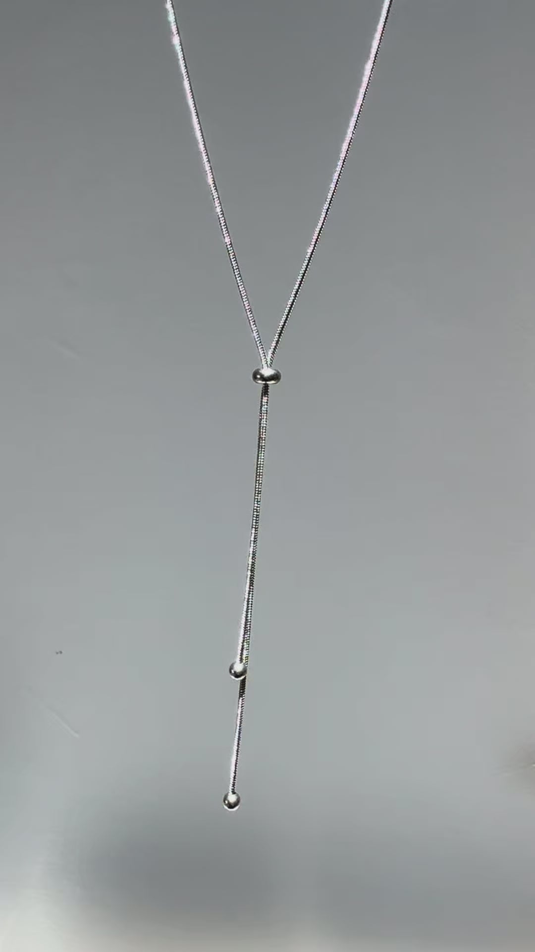 Short looping video of a silver adjustable Y lariat necklace gently swaying and catching light, with the name “Arlena” appearing on screen.